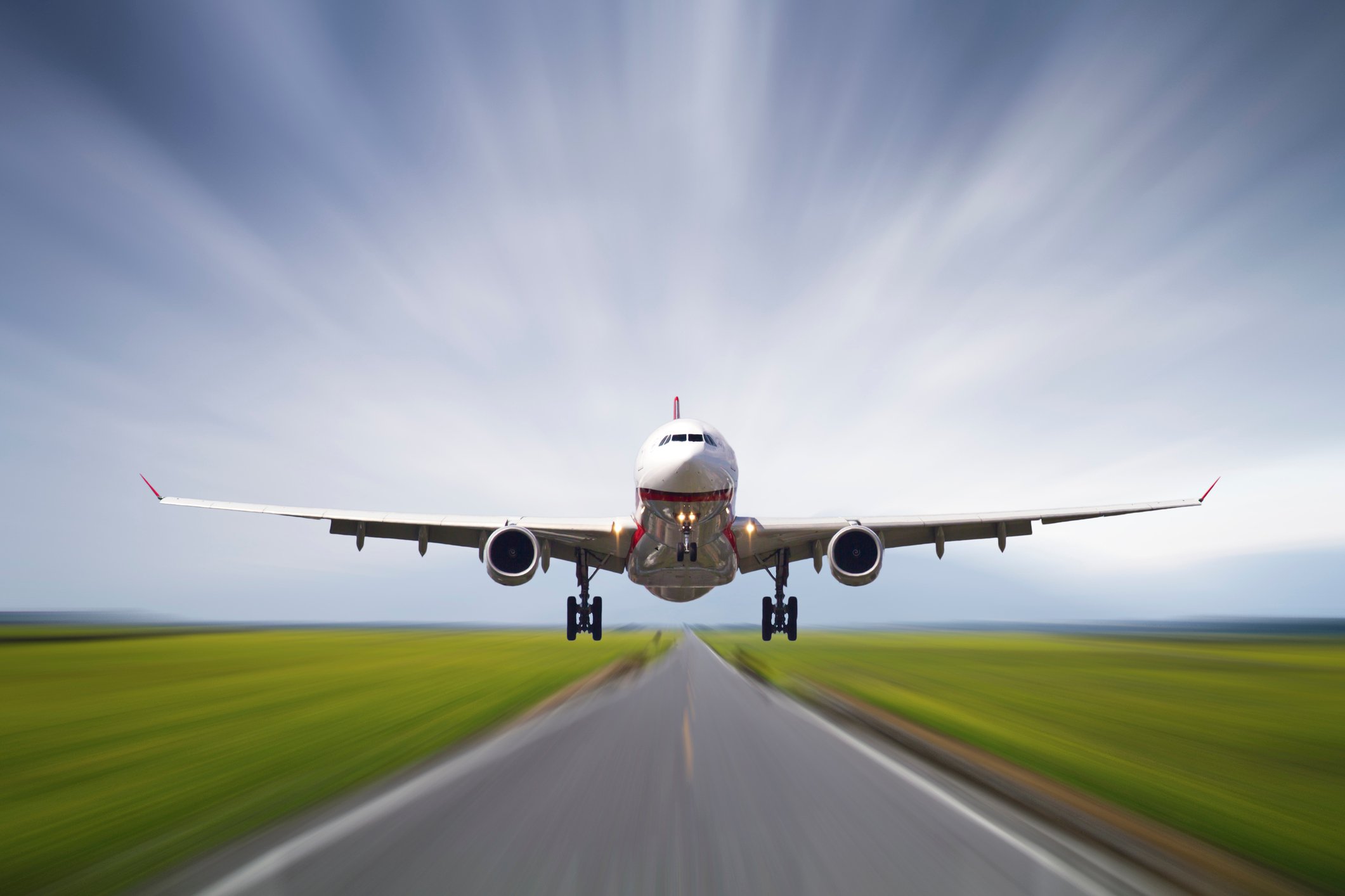 Speeding down the runway, a jumbo jet takes off.