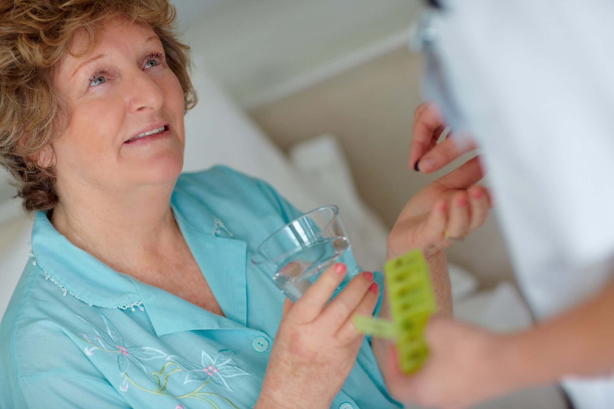 Senior woman receiving pill from doctor