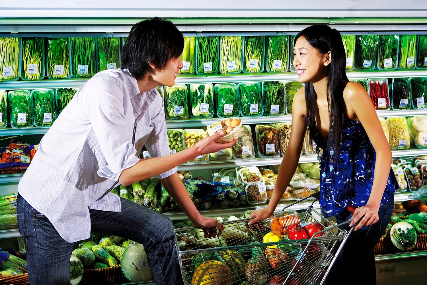 Asian man and woman talking to each other in a supermarket