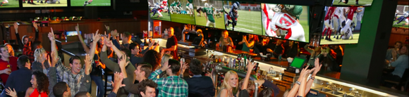 People watching a football game at Dave & Buster's.