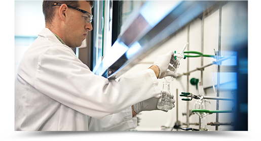 A scientist handles test tubes in a lab