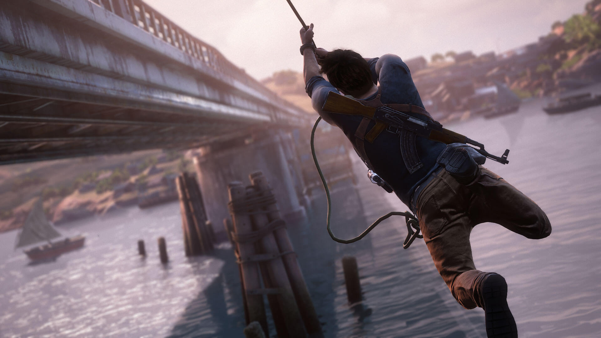 Nathan Drake from Sony's "Uncharted" series swinging from a rope alongside a bridge.