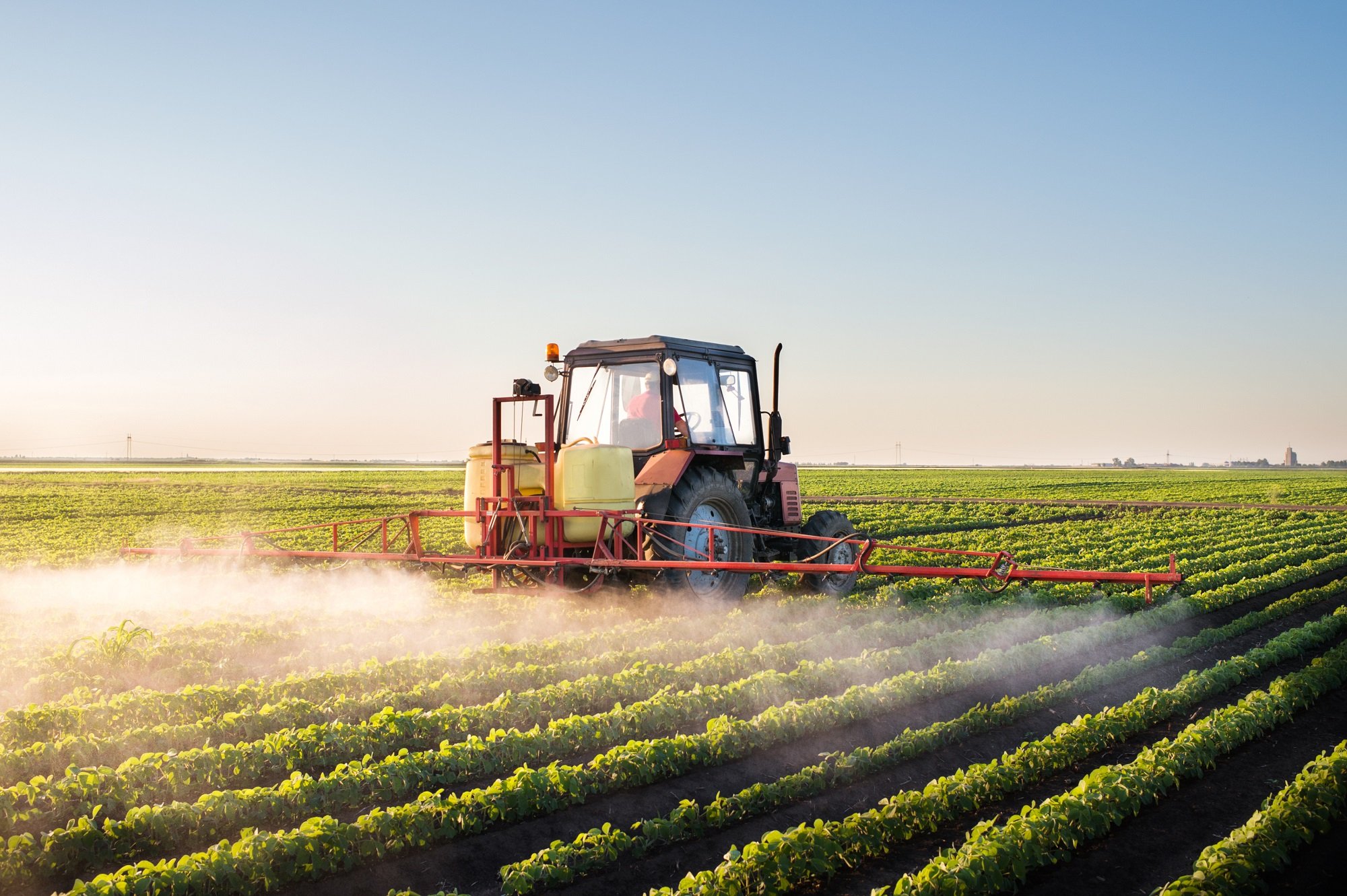 Tractor spraying a soybean field