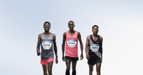 Three runners walk side by side wearing Nike's tech advanced running gear. In the group might be the first (or first three) people to ever run a marathon in under 2 hours.