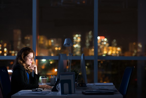 A woman working at her office late into the night.