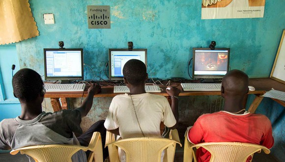 Three local young people sit at computers at a center funded by Cisco in Kenya. 