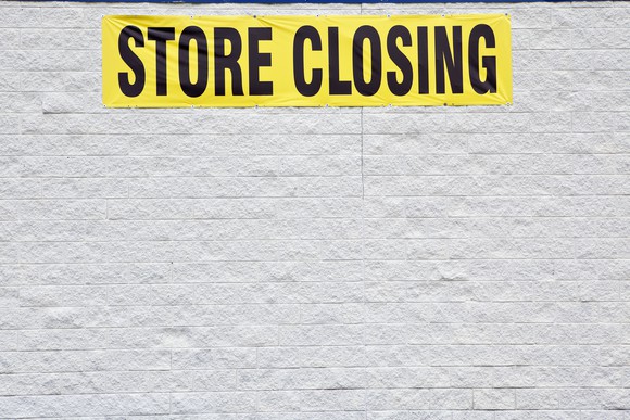 Picture of building with a "store closing" sign.