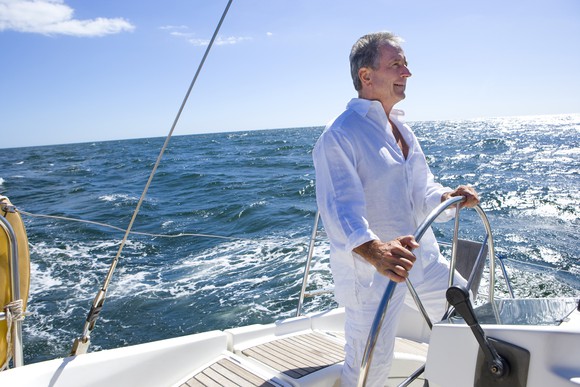 Older man at helm of boat on ocean