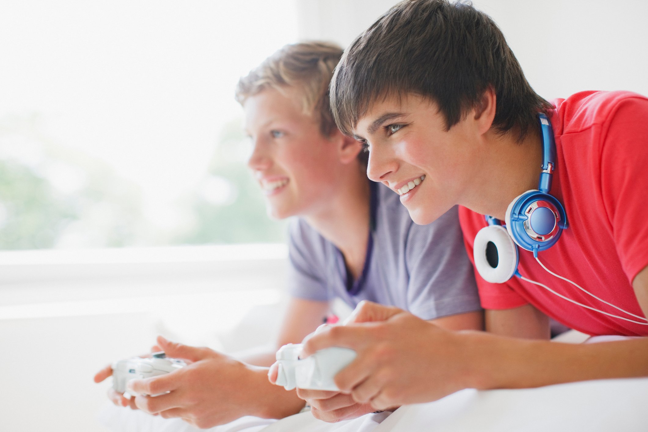 Two teenage boys playing video games.