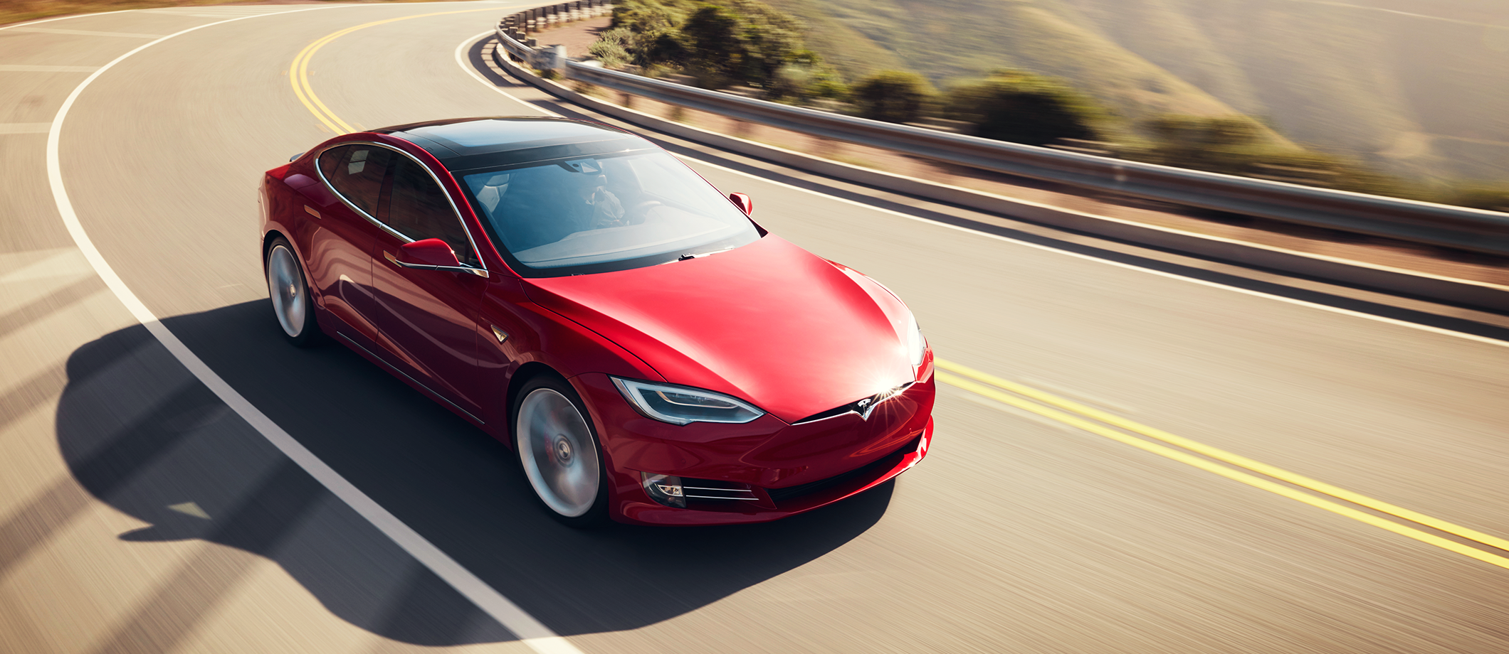 Red Model S driving on a road
