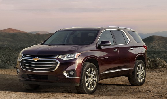 A dark red Traverse, a big crossover SUV, with mountains in the background.
