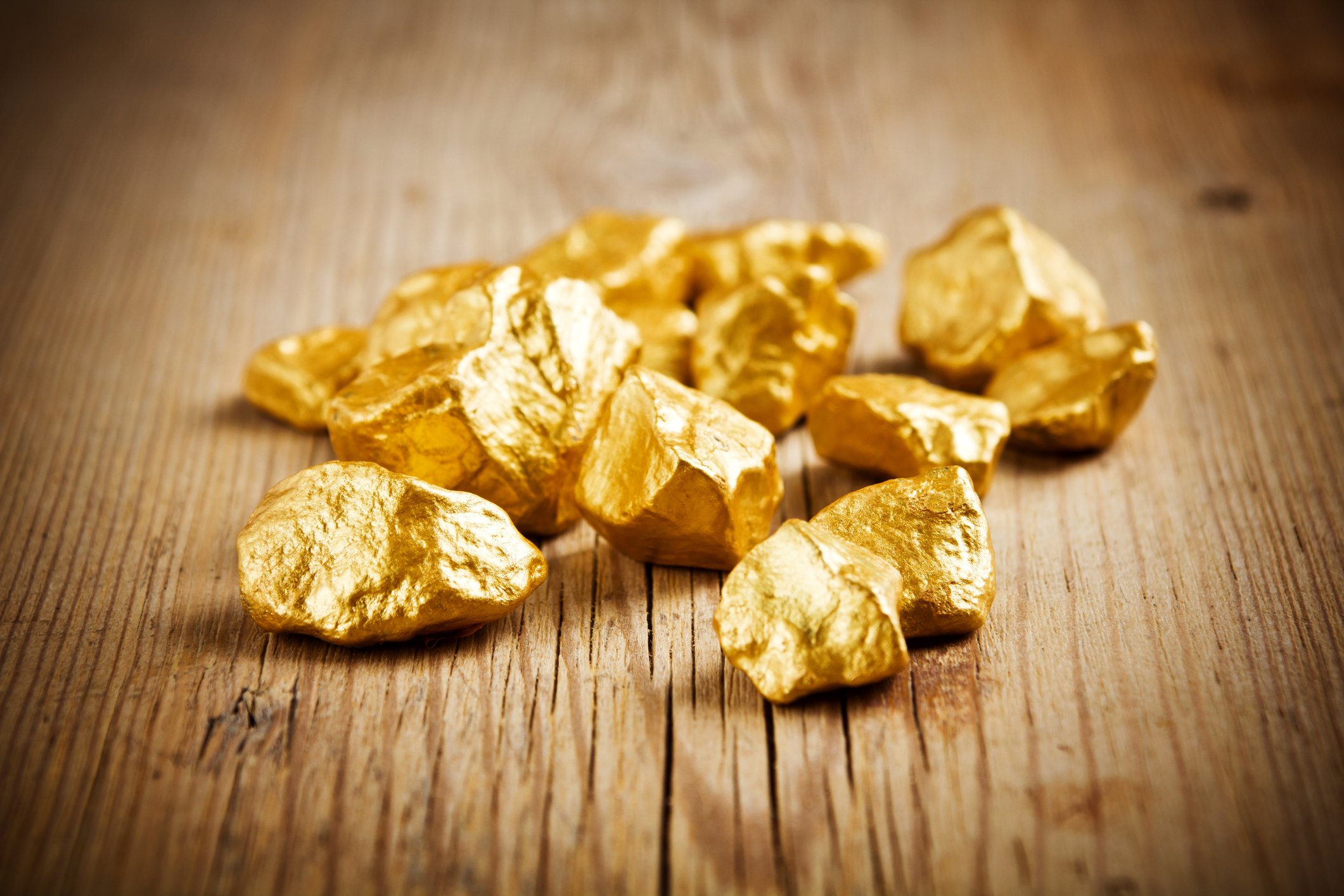 Several gold nuggets on a table.
