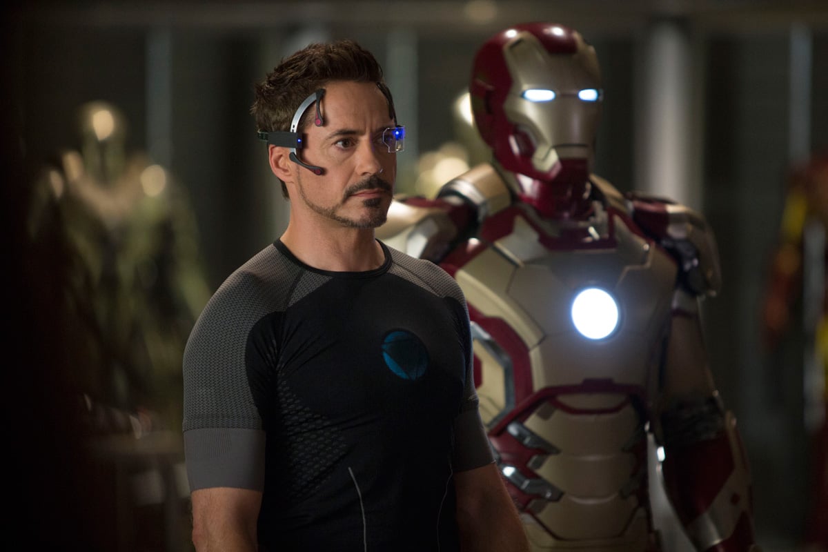 Tony Stark in front of his Iron Man armour.