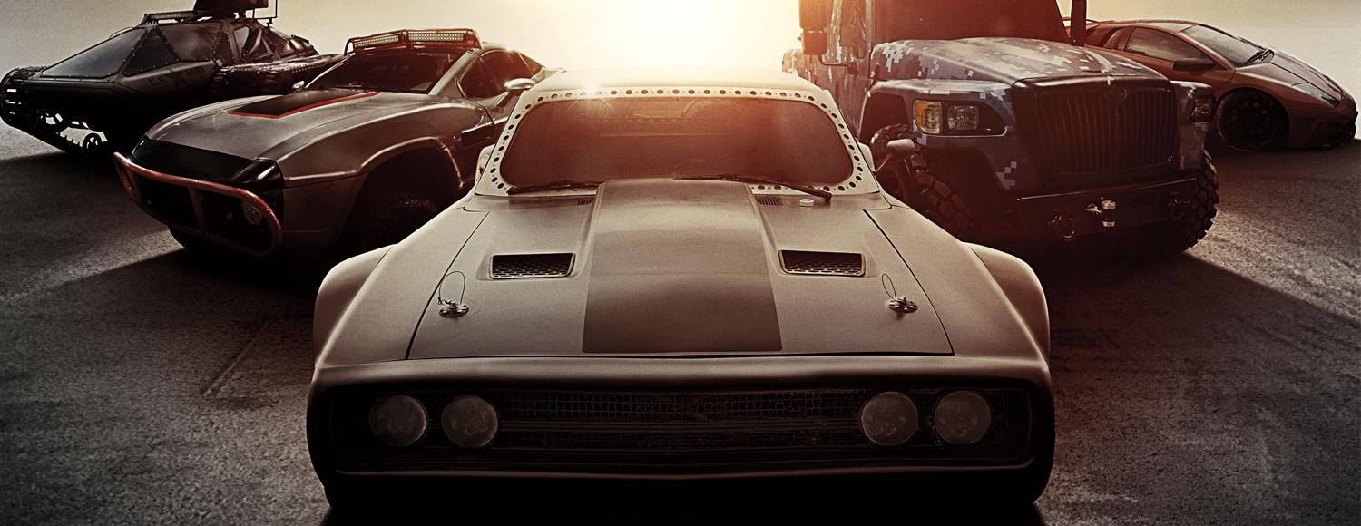 Cars line up with the sun rising behind them.