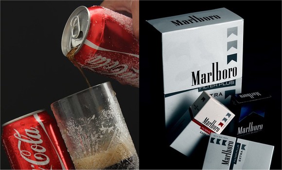 Two cans of Coca-Cola (L) and a few cartons of Marlboro cigarettes (R).