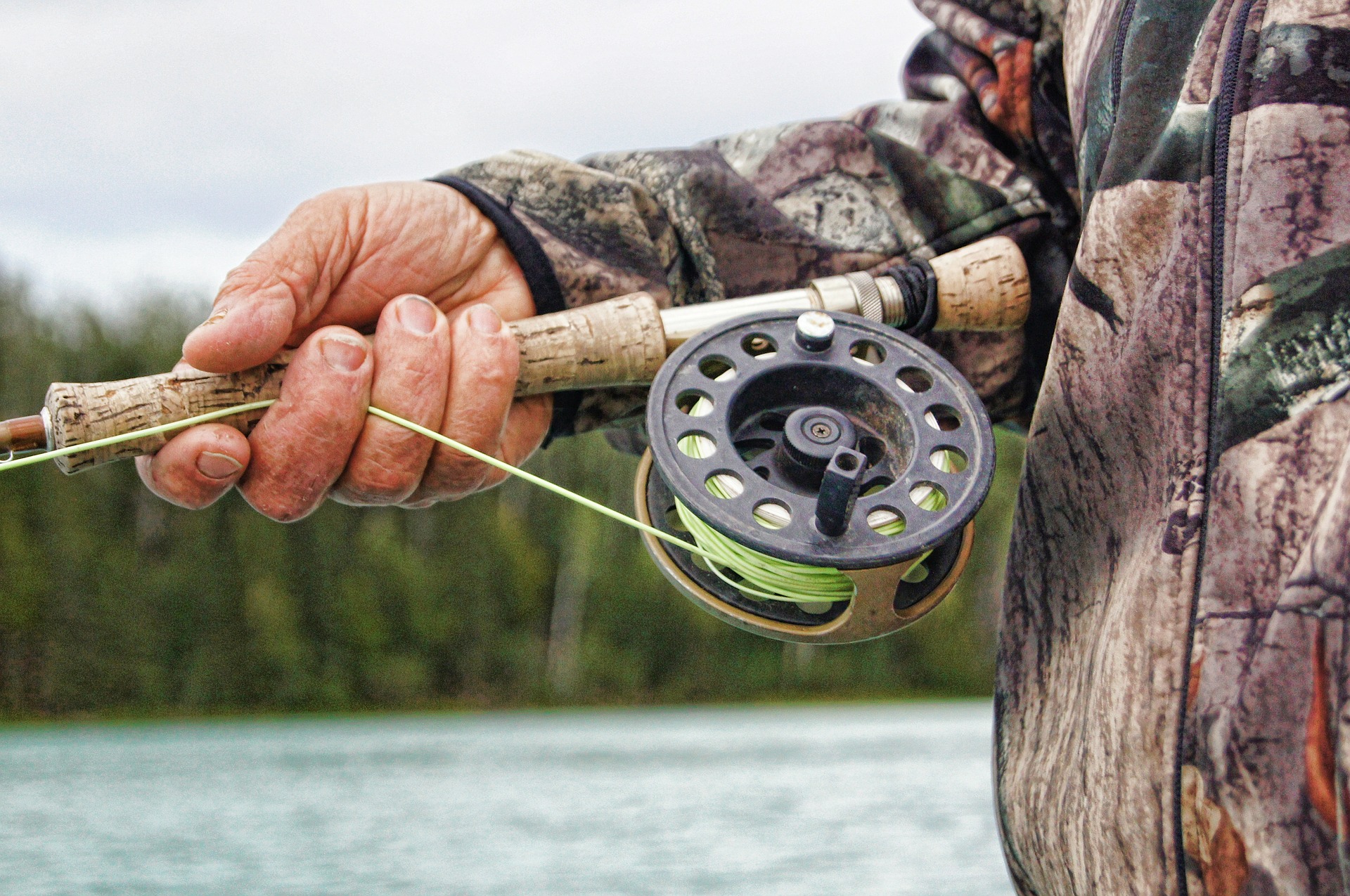 A hand holds a fishing rod.