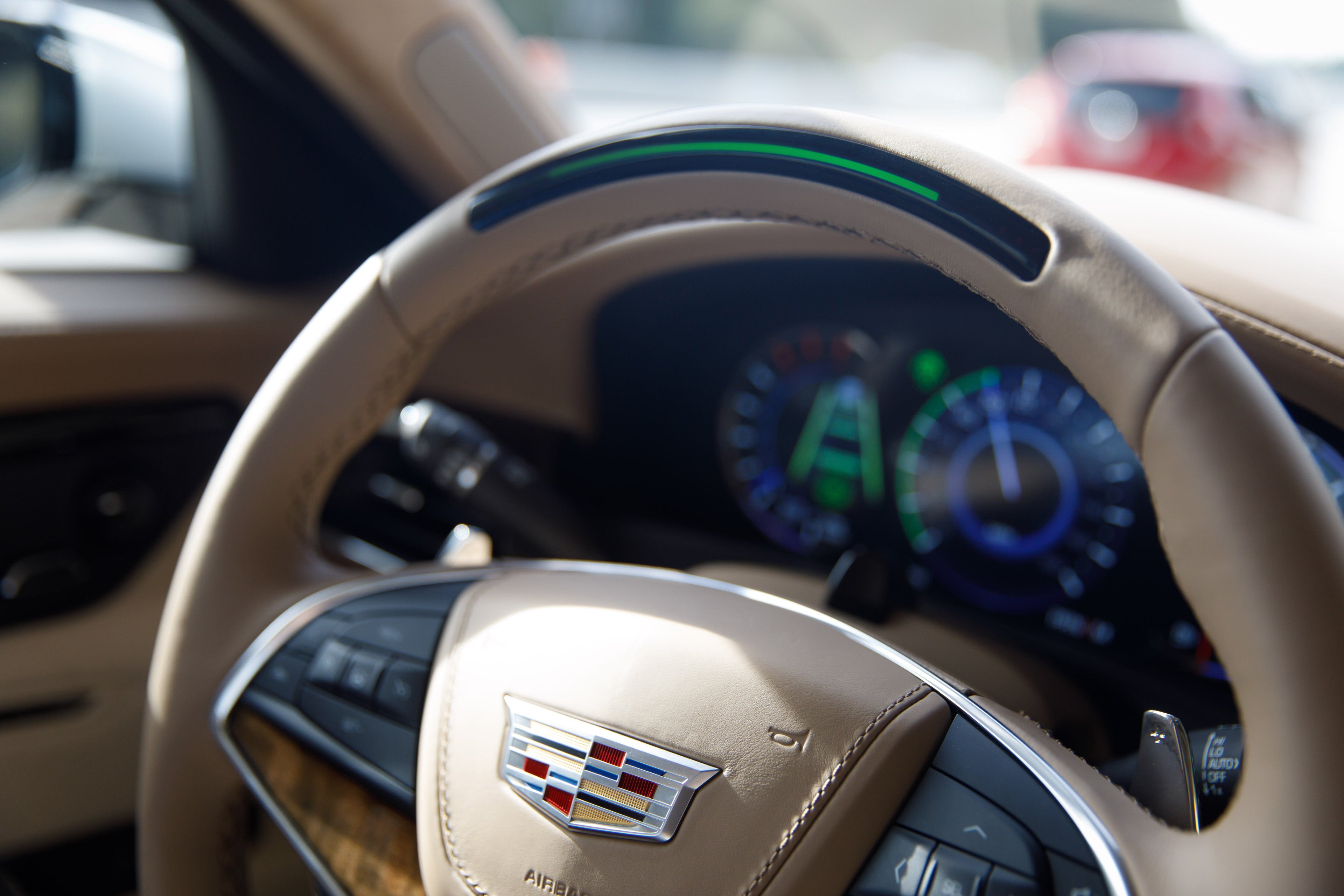 A close up of the Cadillac's steering wheel, showing a light built in. The light is green in the photo.