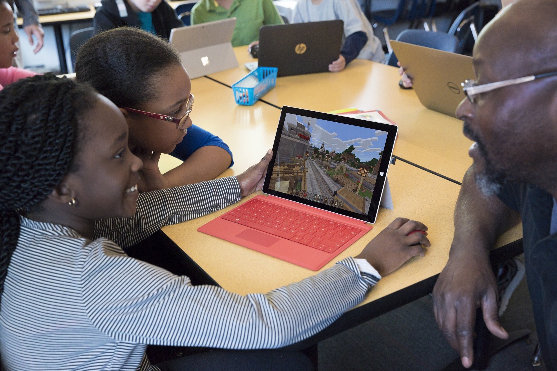 Two girls playing Minecraft on a Microsoft Surface