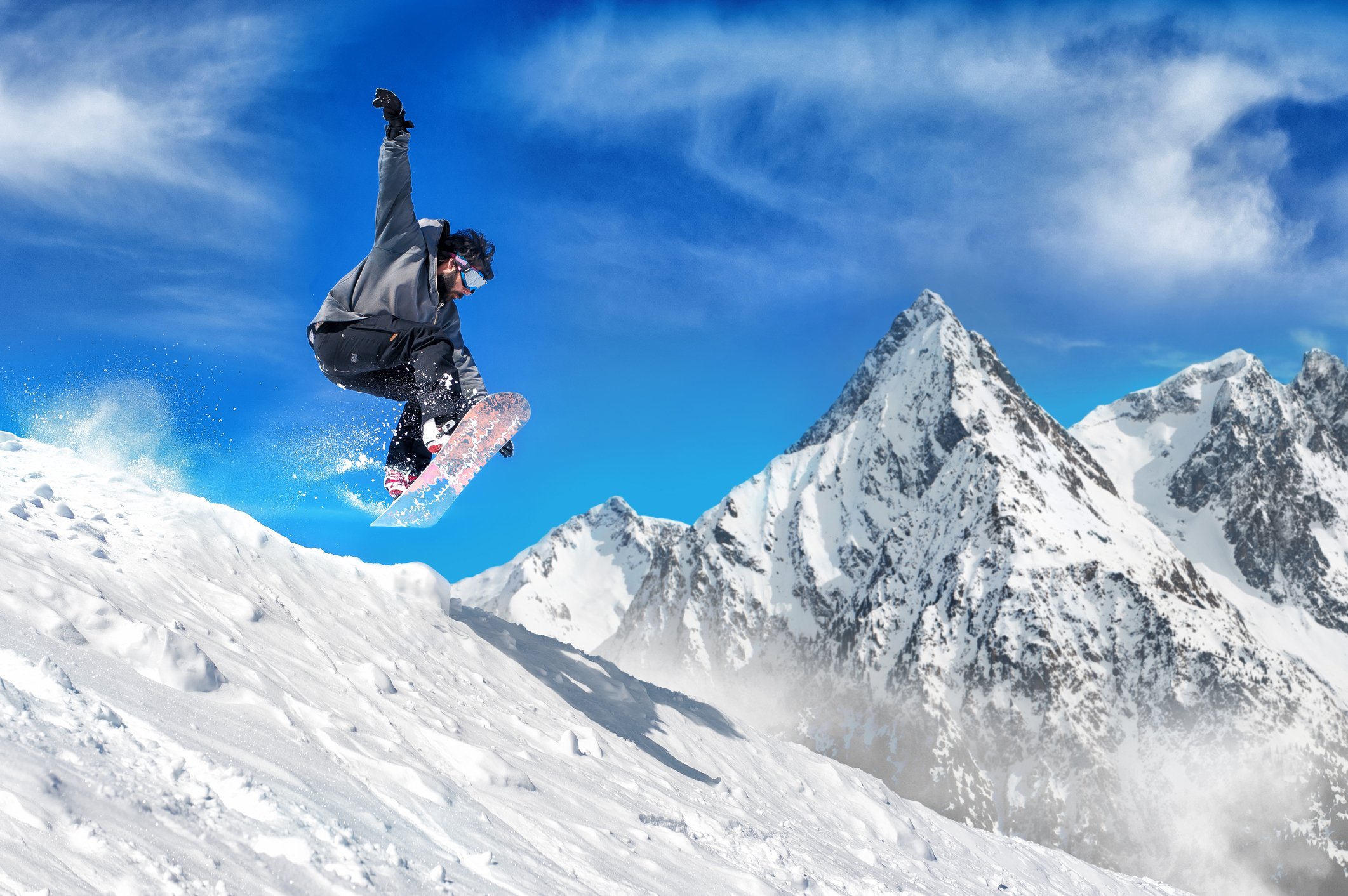 Snowboarder jumping down a mountain