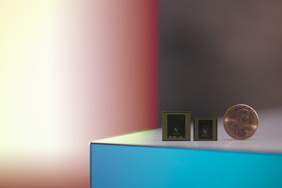 Two Qualcomm Snapdragon processors next to a penny
