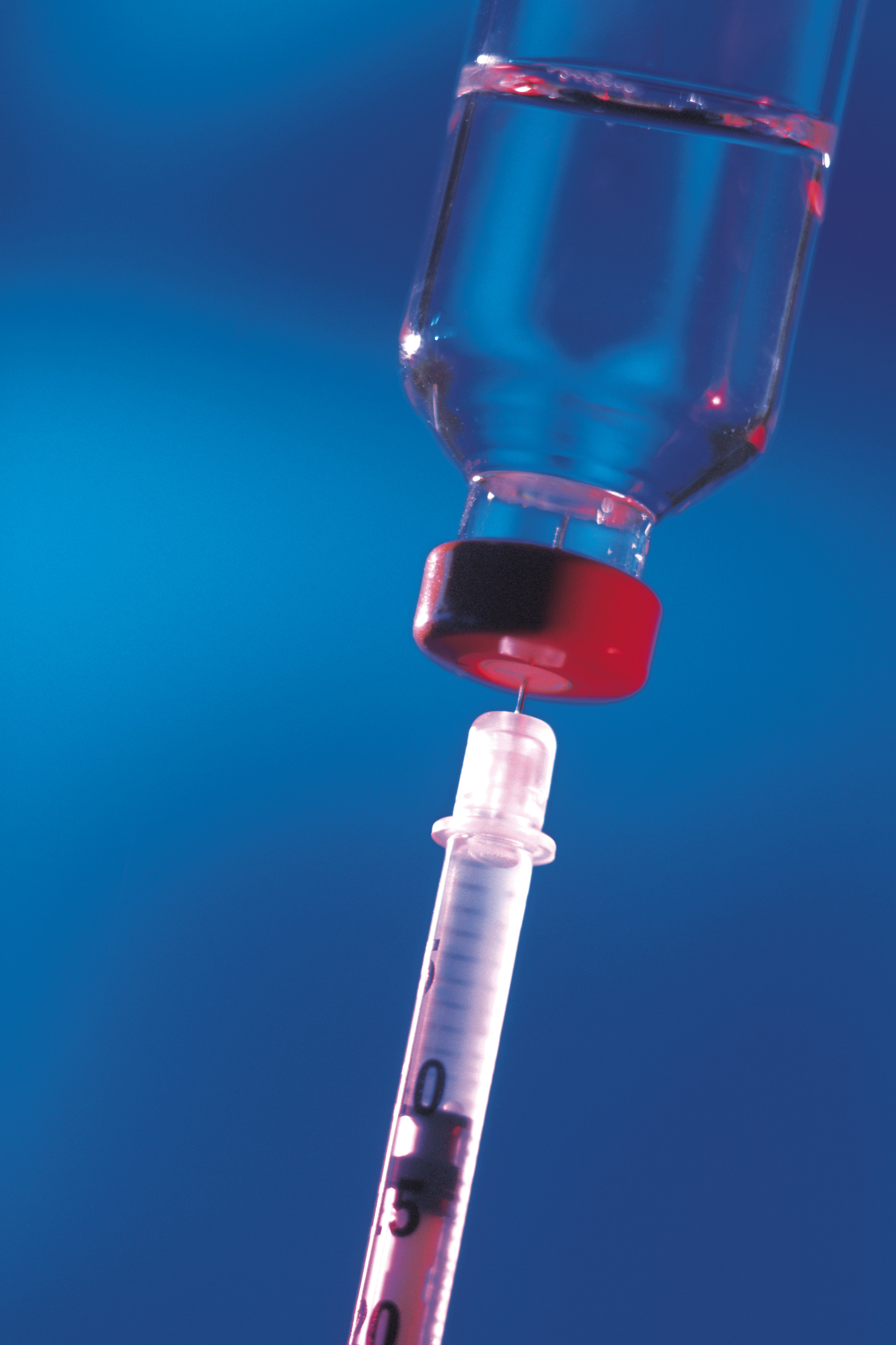 A syringe being filled from a vial