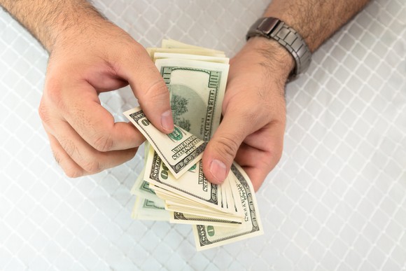 Close-up of a man's hands counting dollar notes