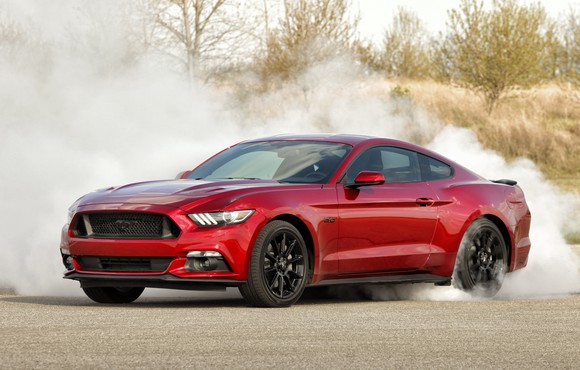 A red Ford Mustang GT spinning its rear tires