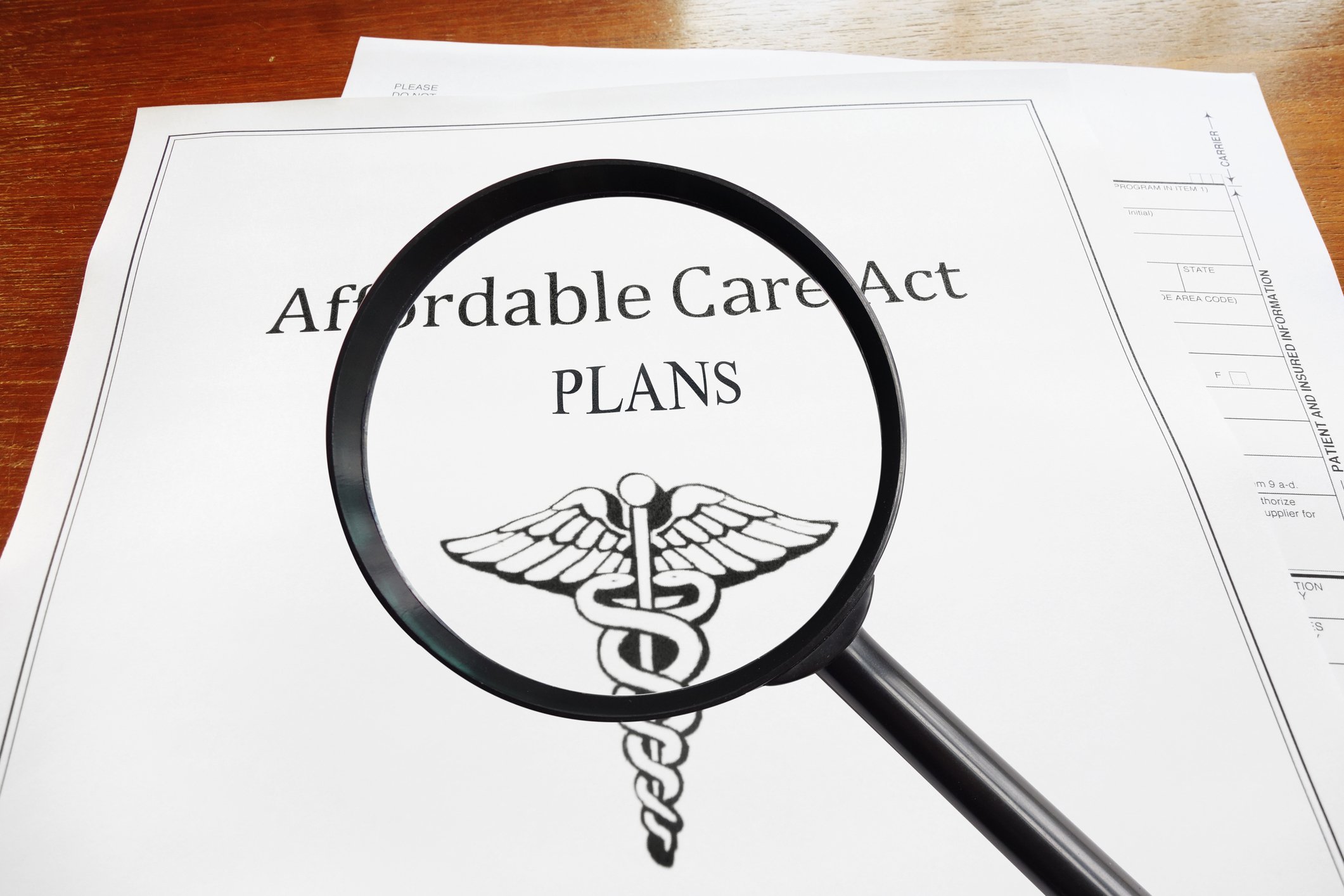 A magnifying glass over an Affordable Care Act policy.