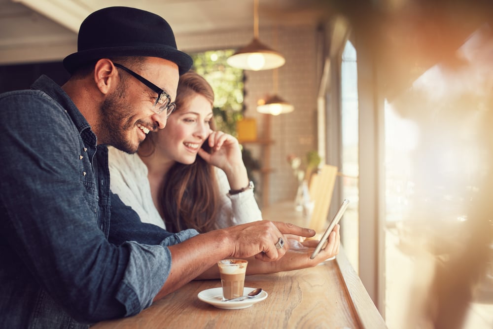 Couple using a mobile device in a coffee shop