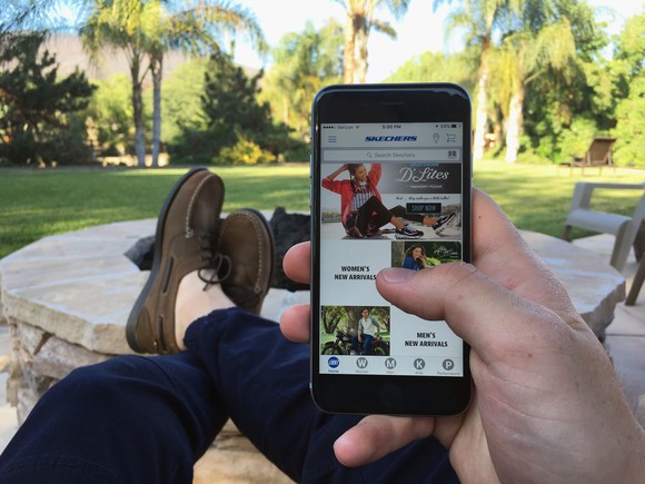 Someone wearing Skechers checking out the Skechers smartphone app.