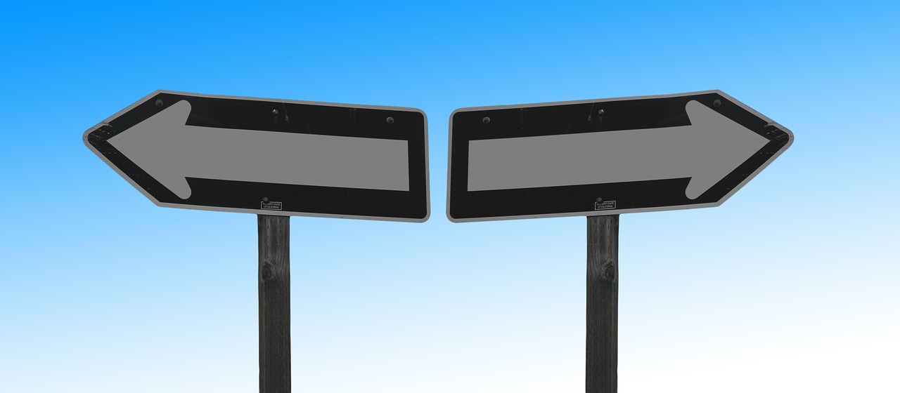 Street signs pointing in two different directions, indicating a crossroads or a metaphorical decision.