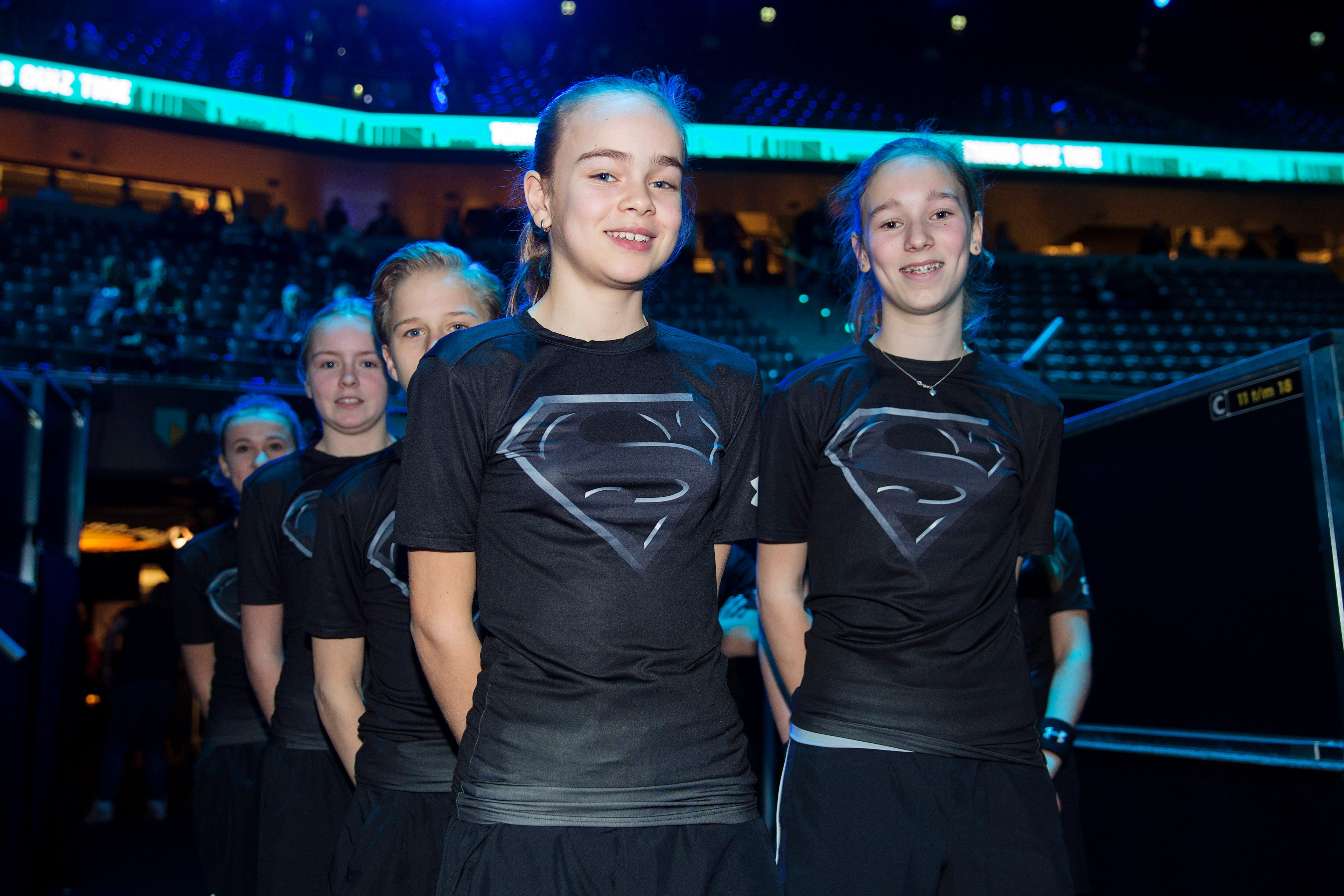 Ballkids at tennis tournament in batman versus superman themed Under Armour t-shirts. 