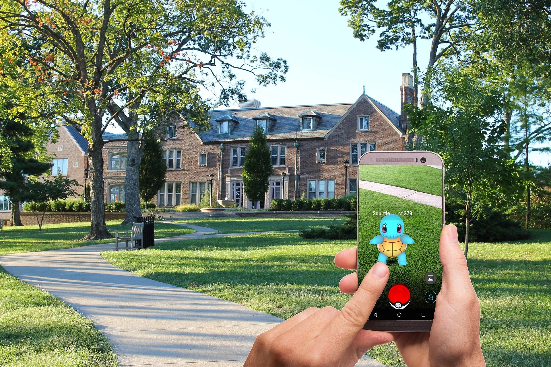 Hands holding a smartphone with Pokemon GO mobile game displayed on smartphone screen.
