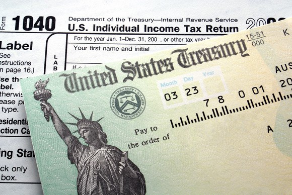 A federal income tax refund check on top of IRS tax form 1040.