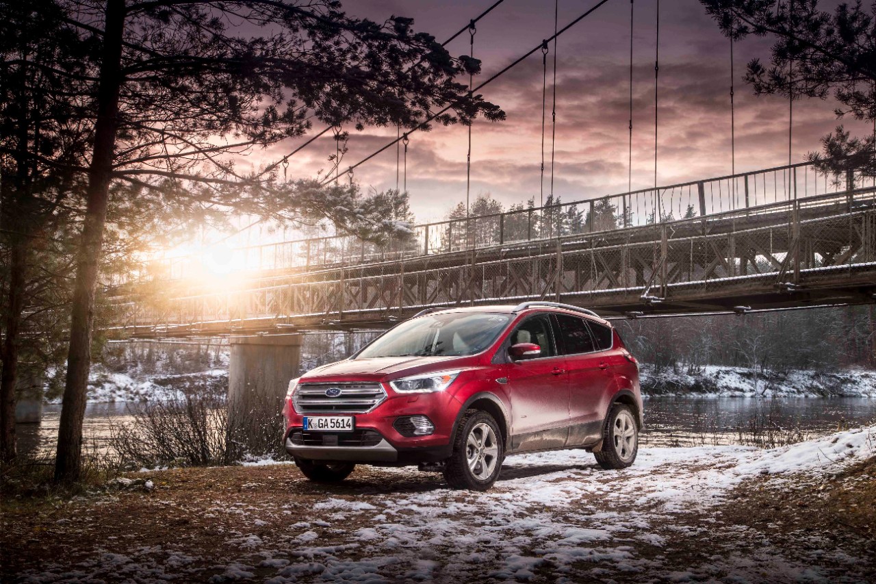 Ford's Kuga parked in front of a bridge against a snow-dusted landscape.