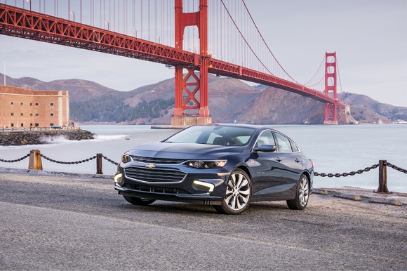 A Chevy Malibu is parked in front of the San Francisco Golden Gate Bridge