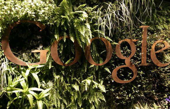 An image of Google's logo blends into the leaf-filled background on the reception desk at Google's offices in Sydney