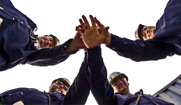 Steelworkers put their hands together in a sign of solidarity.