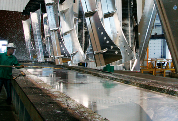 Worker galvanizing a piece of steel