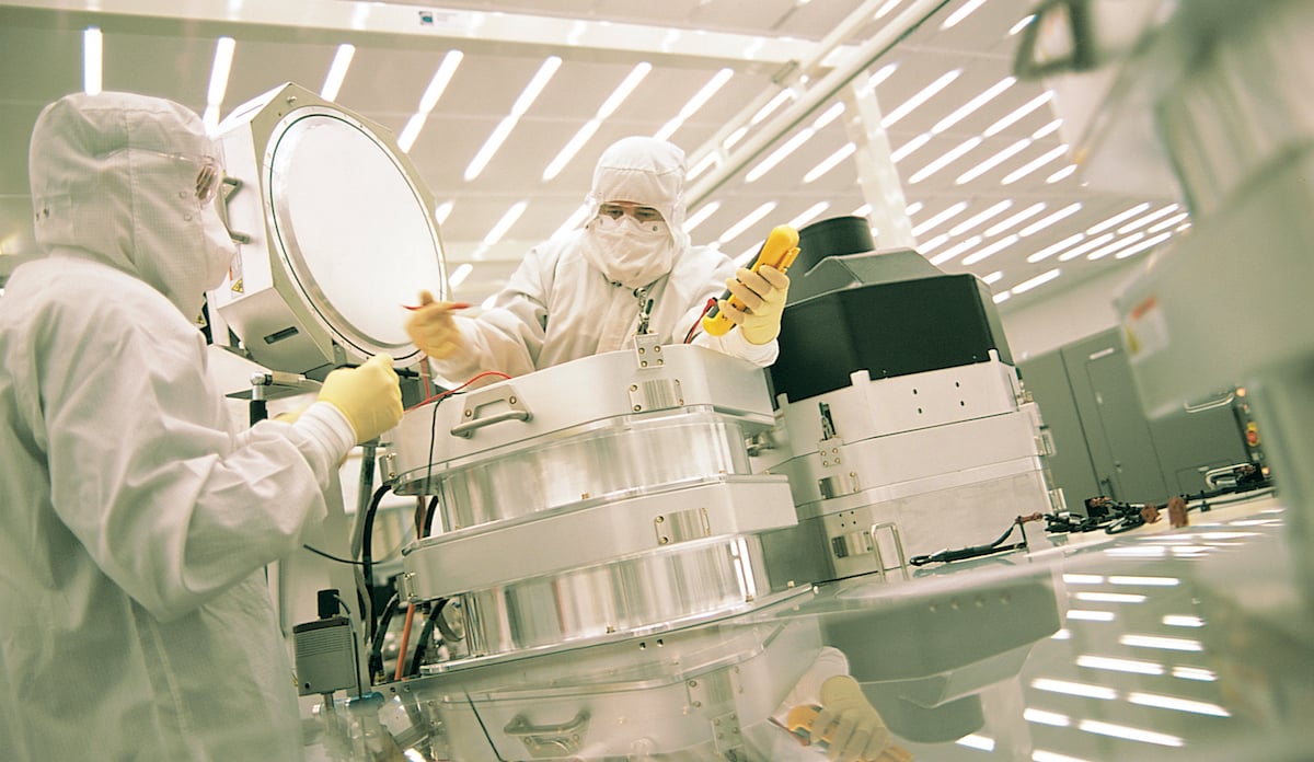 Two people working on semiconductor equipment.