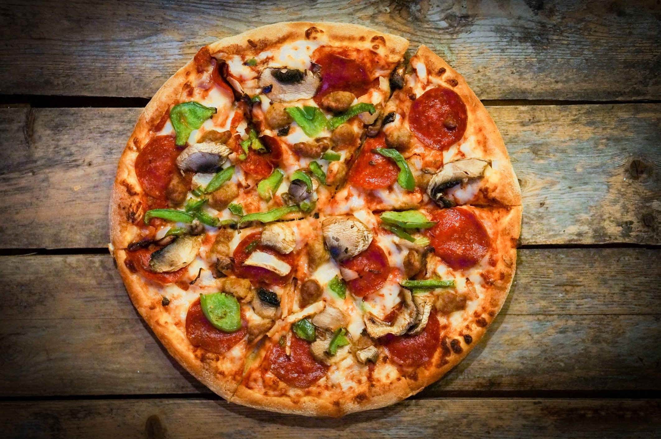 A perfectly prepared pizza with pepperoni and vegetables.