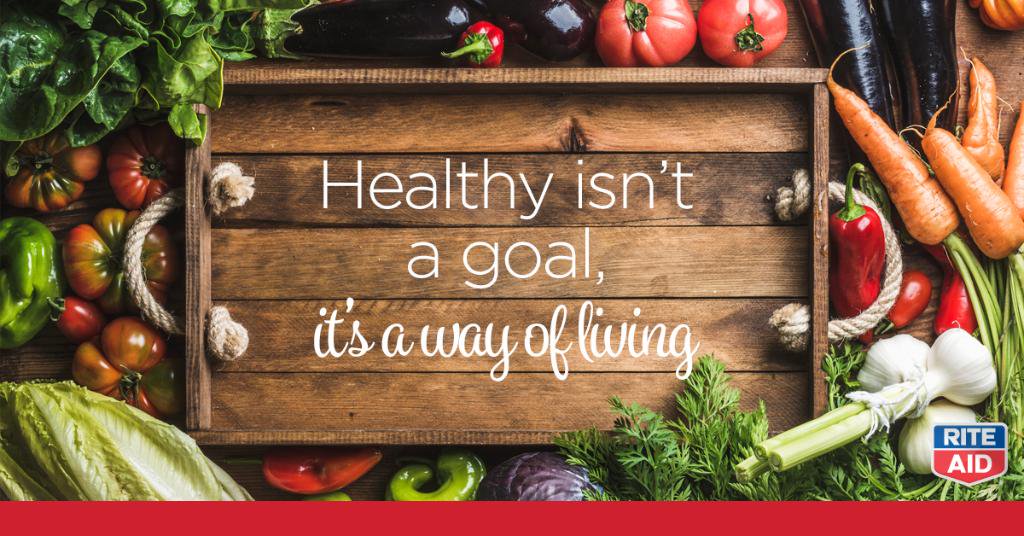 Rite Aid ad with healthy foods surrounding a wooden tray that reads "Healthy isn't a goal, it's a way of living."
