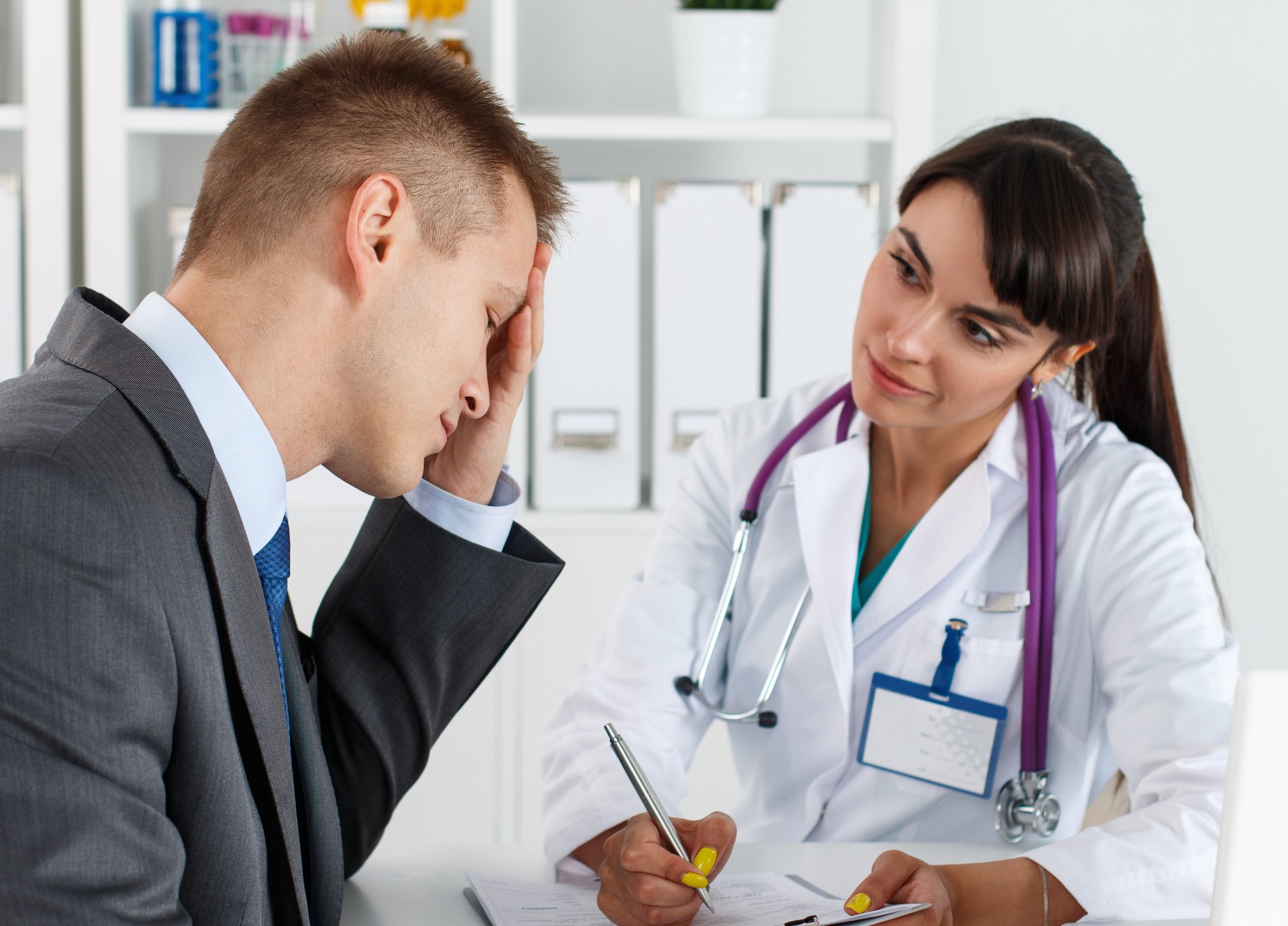 A patient with a migraine speaking to his doctor. 