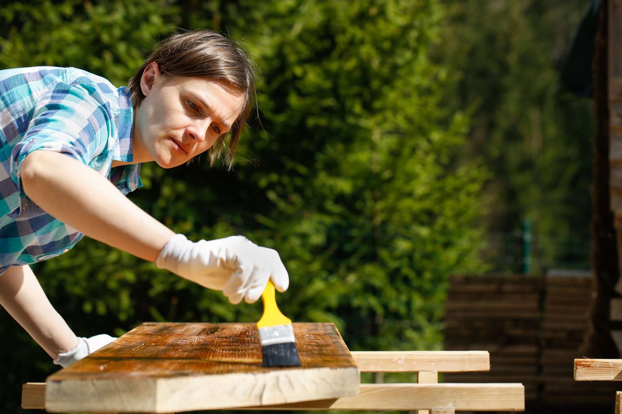 Woman staining lumber