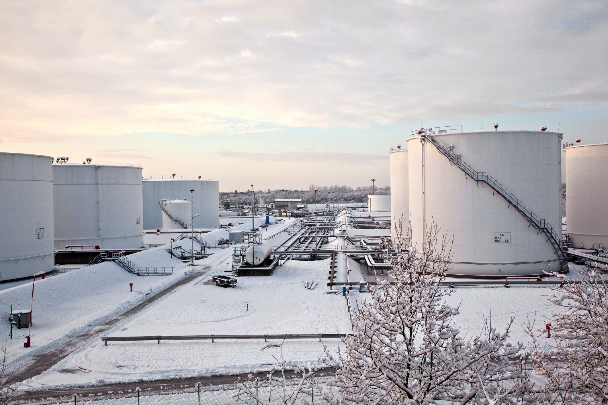 White tanks in tank farm with snow in winter.