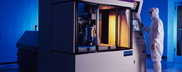 A man using a piece of semiconductor manufacturing equipment.