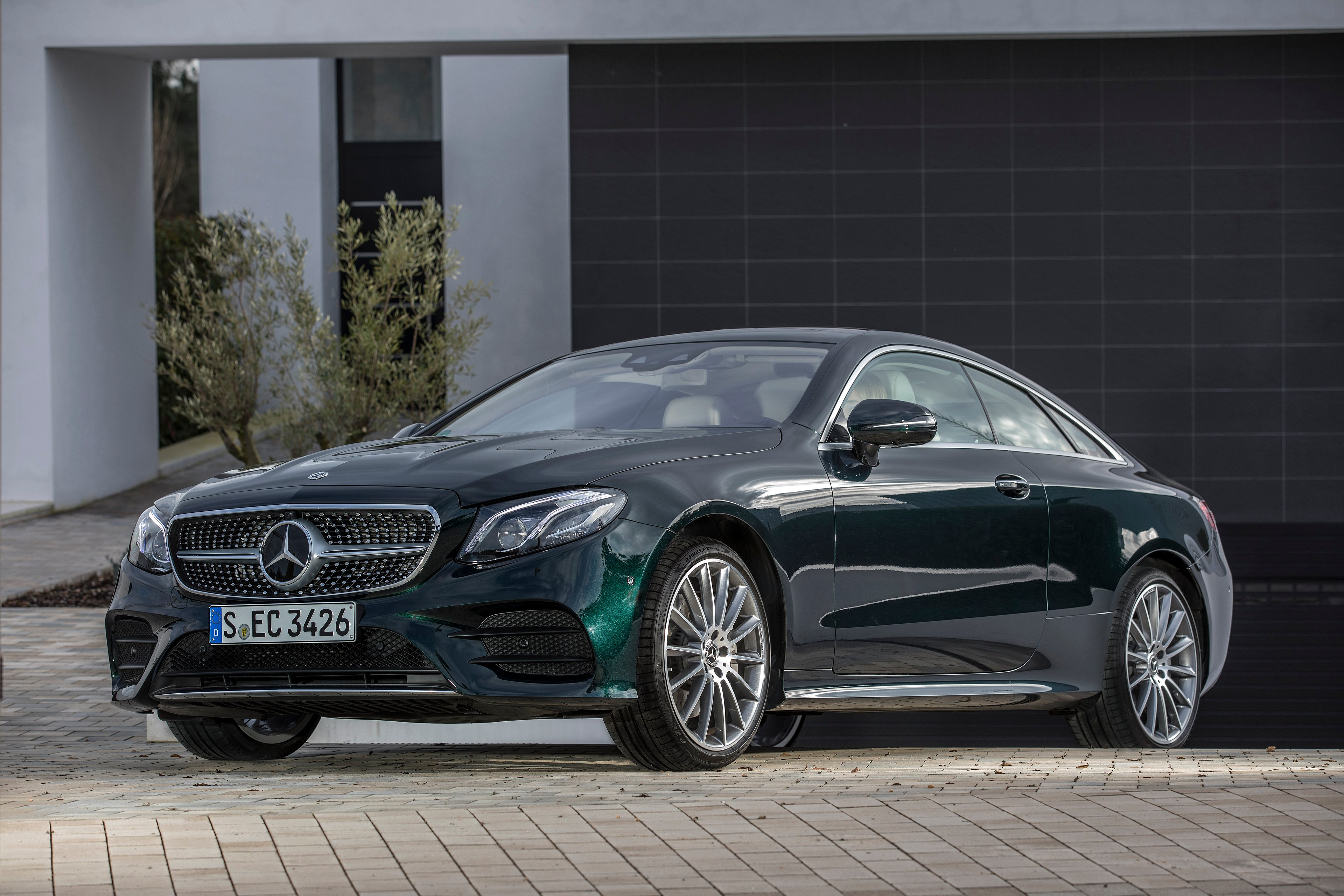 A green Mercedes-Benz E-Class coupe.