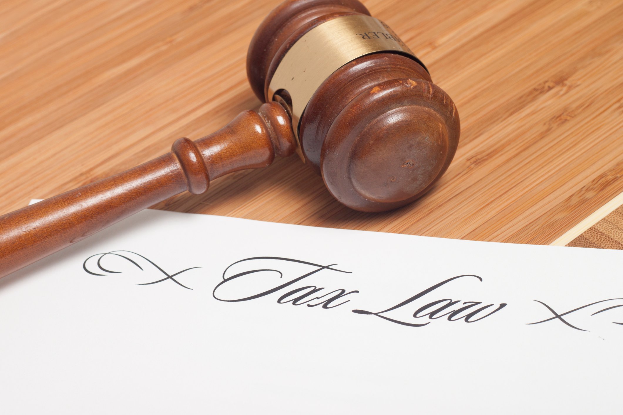 A judge's gavel sitting next to corporate tax law paperwork.