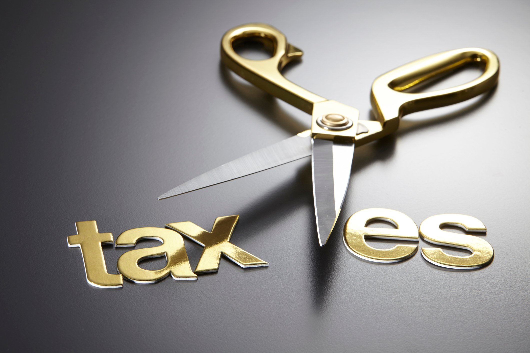 Scissors cutting through the word "taxes."
