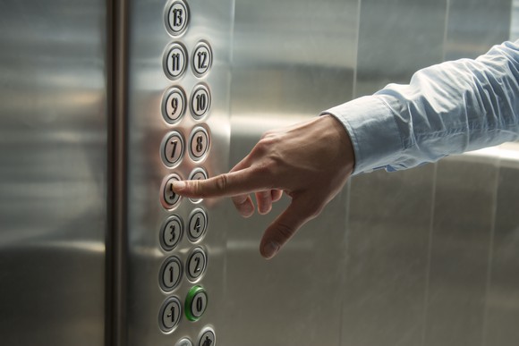 Finger pressing an elevator button